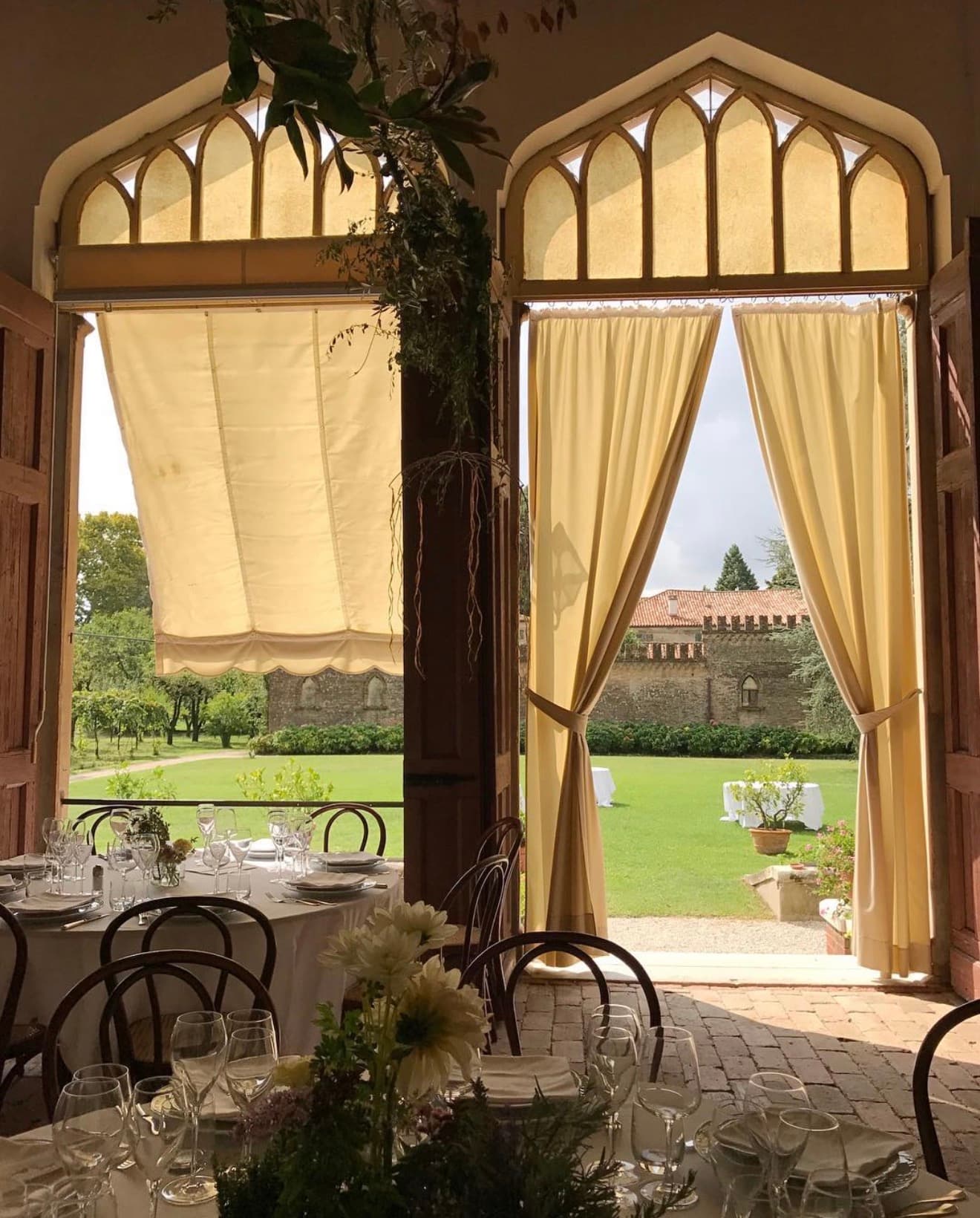 Sala interna dell’Aranciera con vista sul parco e sulle mura merlate